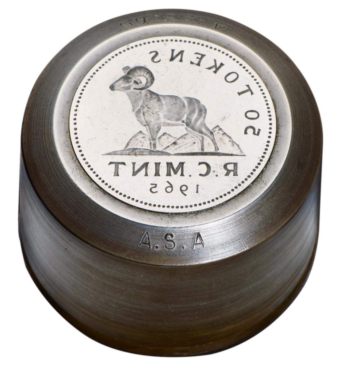 Steel cylinder with a reversed coin design of a goat in front of mountains.